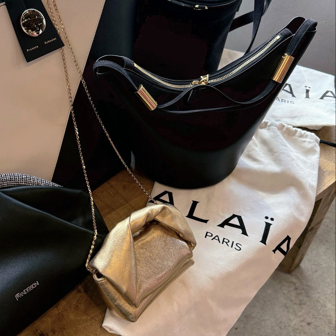 Collection of designer handbags from Alaia, JW Anderson and Proenza on a table