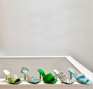 Row of 5 Bottega Venetta high heel sandals in mint green quilted leather, blue crystal netting with ankle tie, dark green woven leather, silver braided leather, and light blue shearling